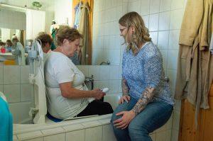 Stefanie Schmelzer erklärt Patientin Badewannenlifter